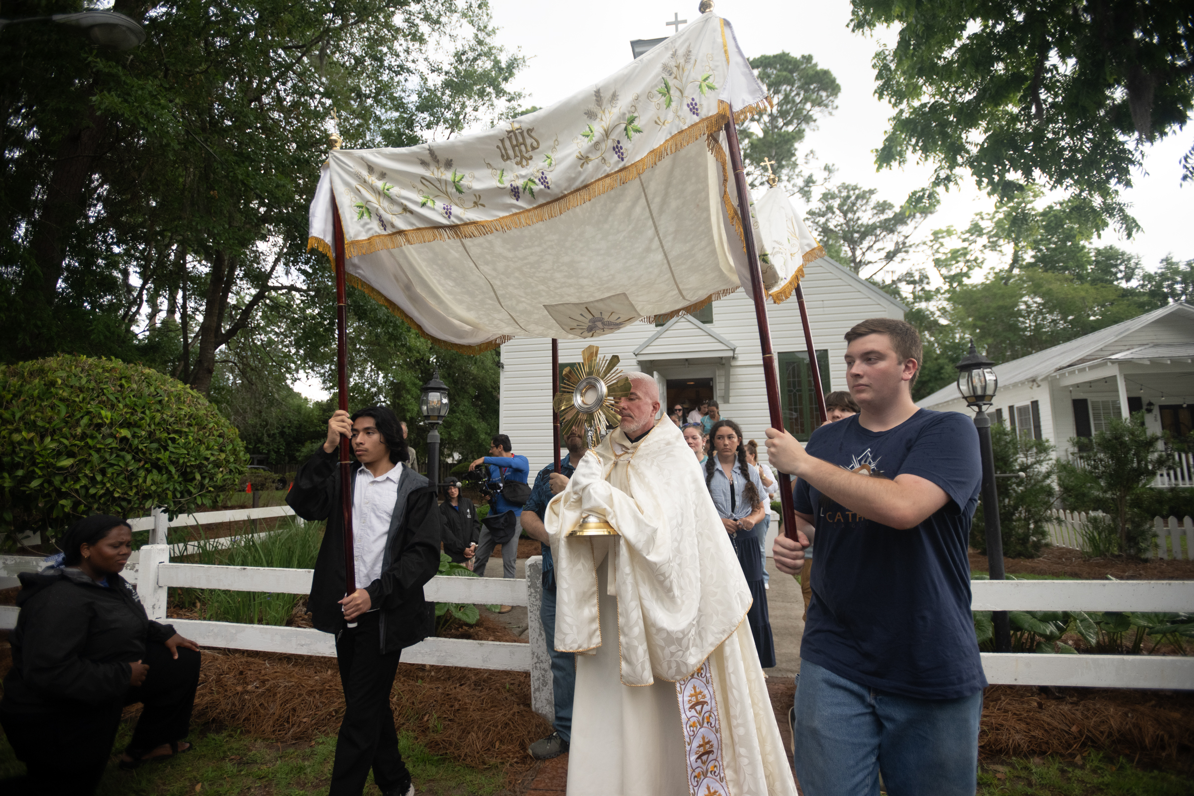 A priest carries the Blessed Sacrament beneath a canopy as a Eucharistic procession departs from historic Our Lady of Good Hope in Savannah, Georgia. | Credit: Jeffrey Bruno