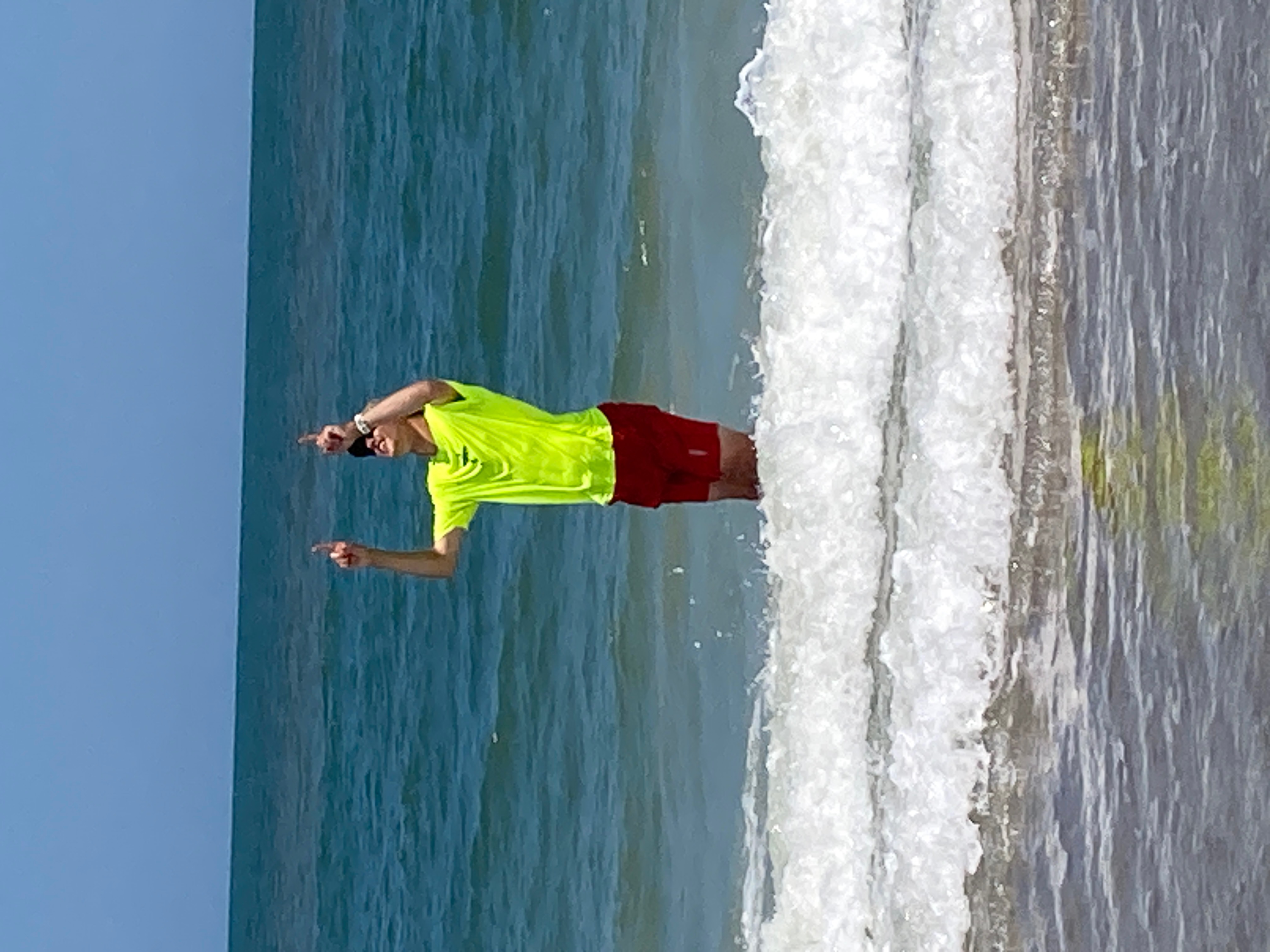 Jared Plasberg points to the heavens at the end of his run across the country in the Atlantic Ocean on June 12, 2026. The phrase 