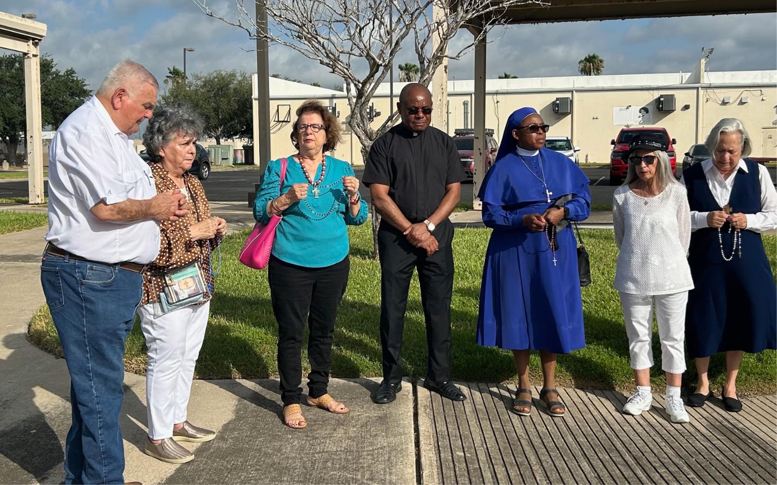 Personas que apoyan a la hermana Leticia Ugboaja, entre ellas la hermana Norma Pimentel, a la derecha, rezan el Rosario fuera de una oficina local del ICE en Harlingen, Texas, mientras esperan noticias sobre el caso migratorio de Ugboaja, el 28 de julio de 2026. Crédito: Amira Abuzeid/EWTN News.