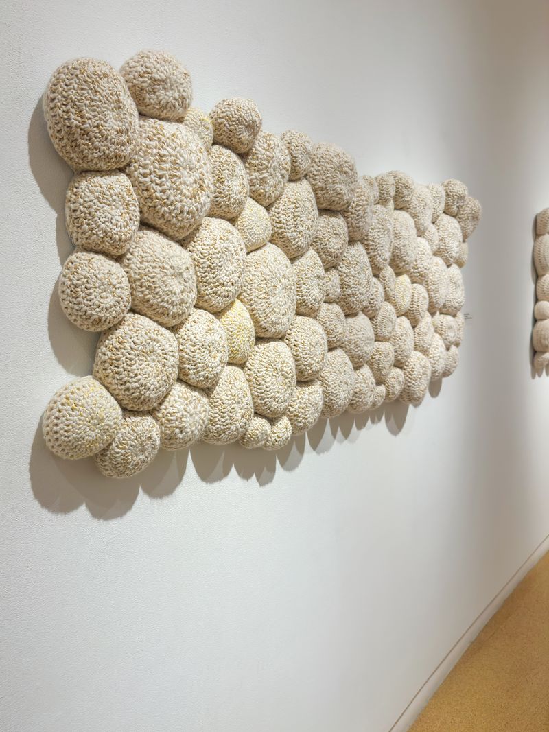 Part 1 of 3 of the Kerygma series in Holly Guertin’s “Hand in Hand” exhibition, “The Intimacy” is made of crocheted wool yarn, wool fill, and reclaimed cotton domestic fabric backing. Completed in 2022, Guertin’s work is more than 2 feet tall, more than 5 feet wide, and 4 inches deep. | Credit: Holly Guertin