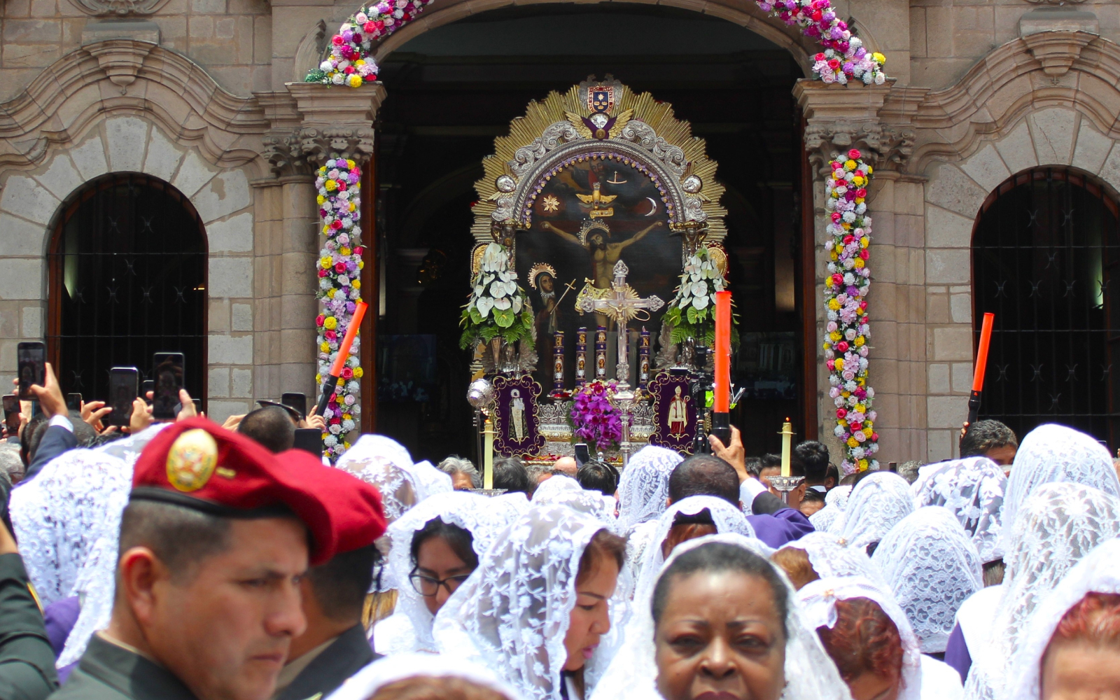 Miles de personas acuden a adorar al Señor de los Milagros durante la procesión en el centro de Lima, Perú.