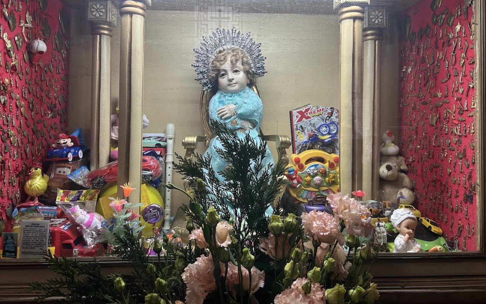 Imagen del Divino Niño de Santa Rosa de Lima, rodeada de juguetes y pequeños obsequios dejados por sus devotos. | Crédito: David Ramos/EWTN News.