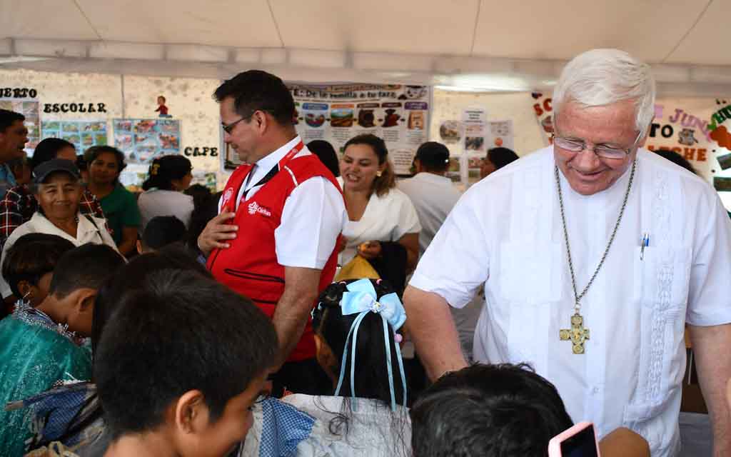 El Obispo de Santo Domingo (Ecuador), Mons. Bertram Wick Enzler, con algunos niños emprendedores. Crédito: Cáritas Ecuador.