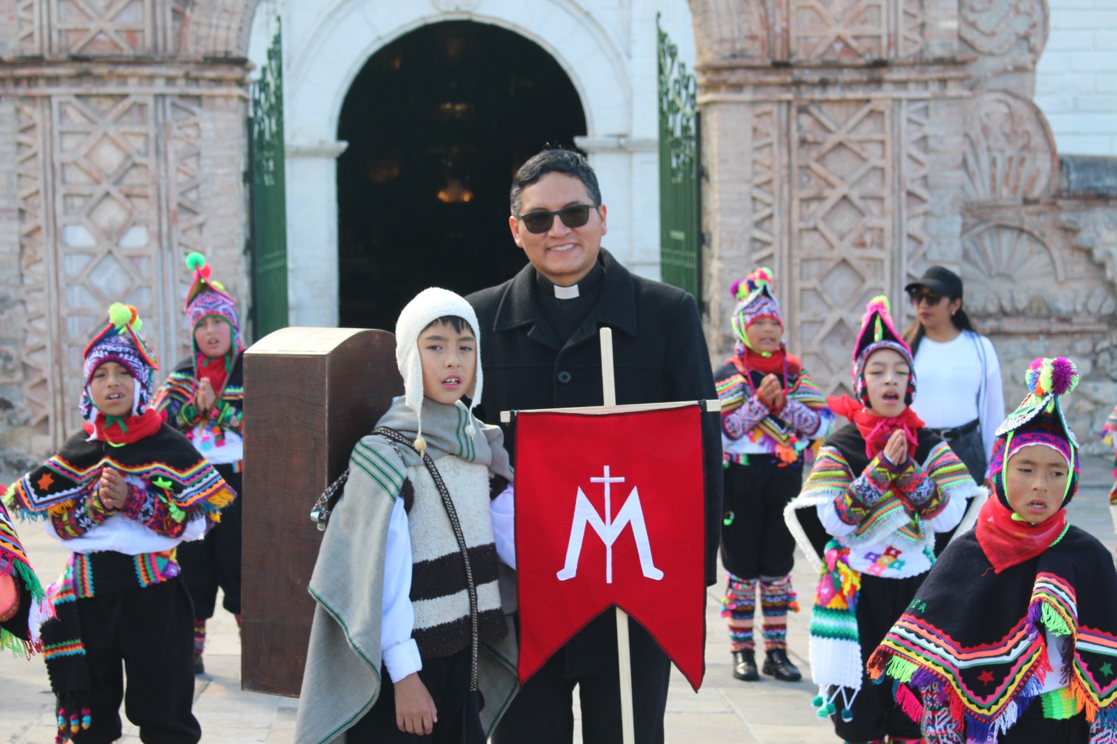 El P. Carlos López y el Coro de Niños Acólitos. Crédito: Cortesía