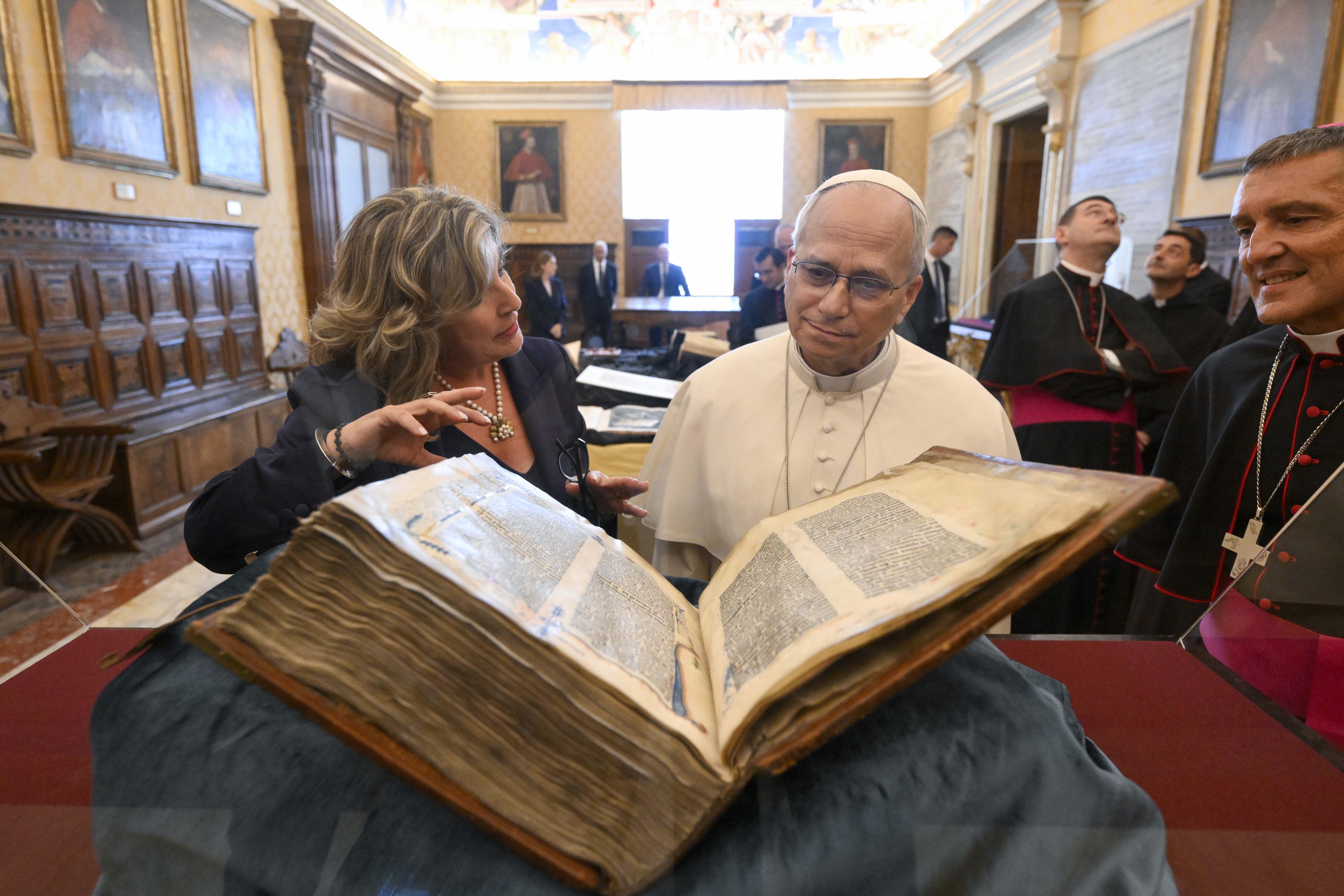 El Papa León XIV examina un libro de la Biblioteca Apostólica. | Crédito: Vatican Media.