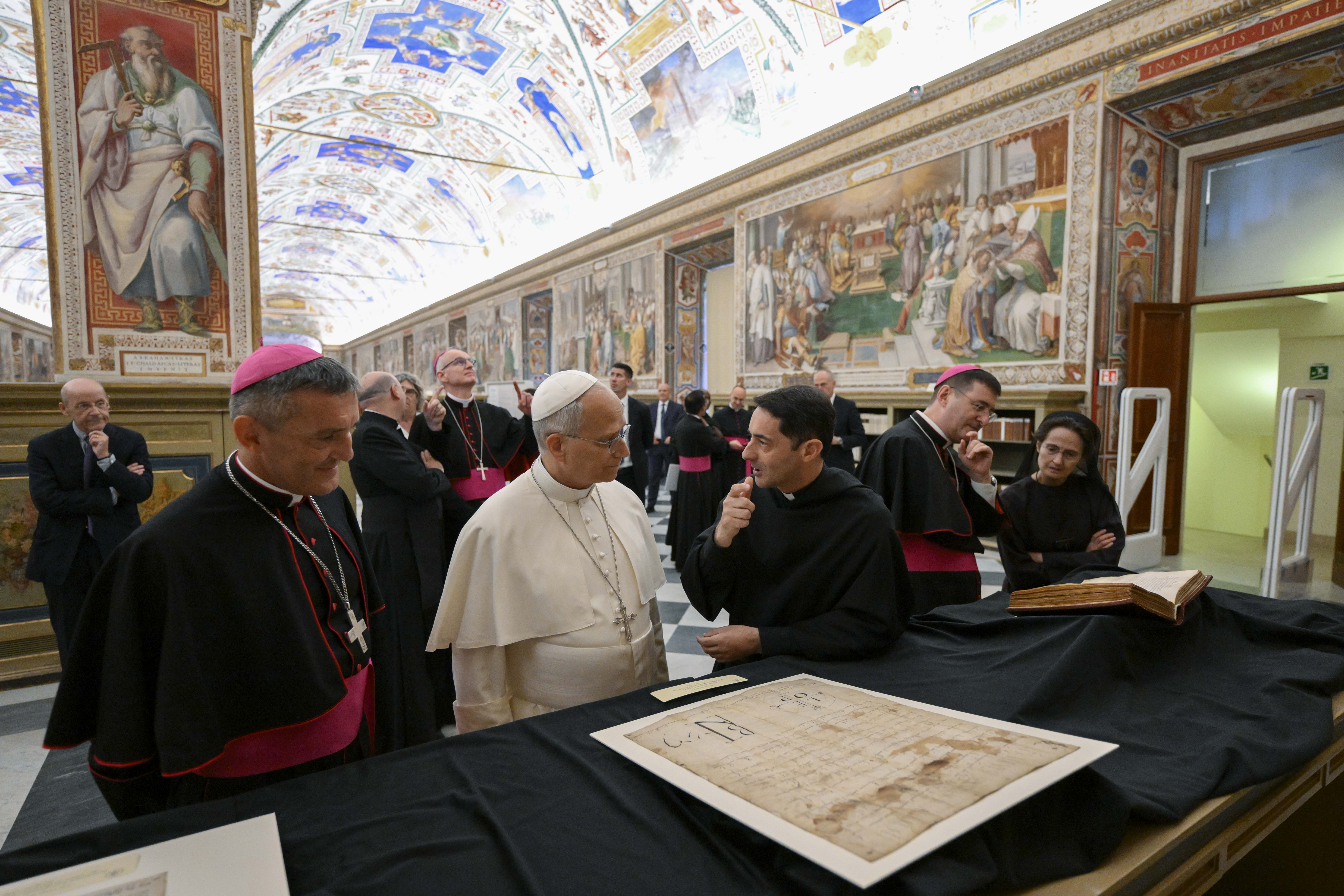 El Papa León XIV atiende las explicaciones sobre un manuscritos conservado en la Biblioteca Apostólica. | Crédito: Vatican Media.