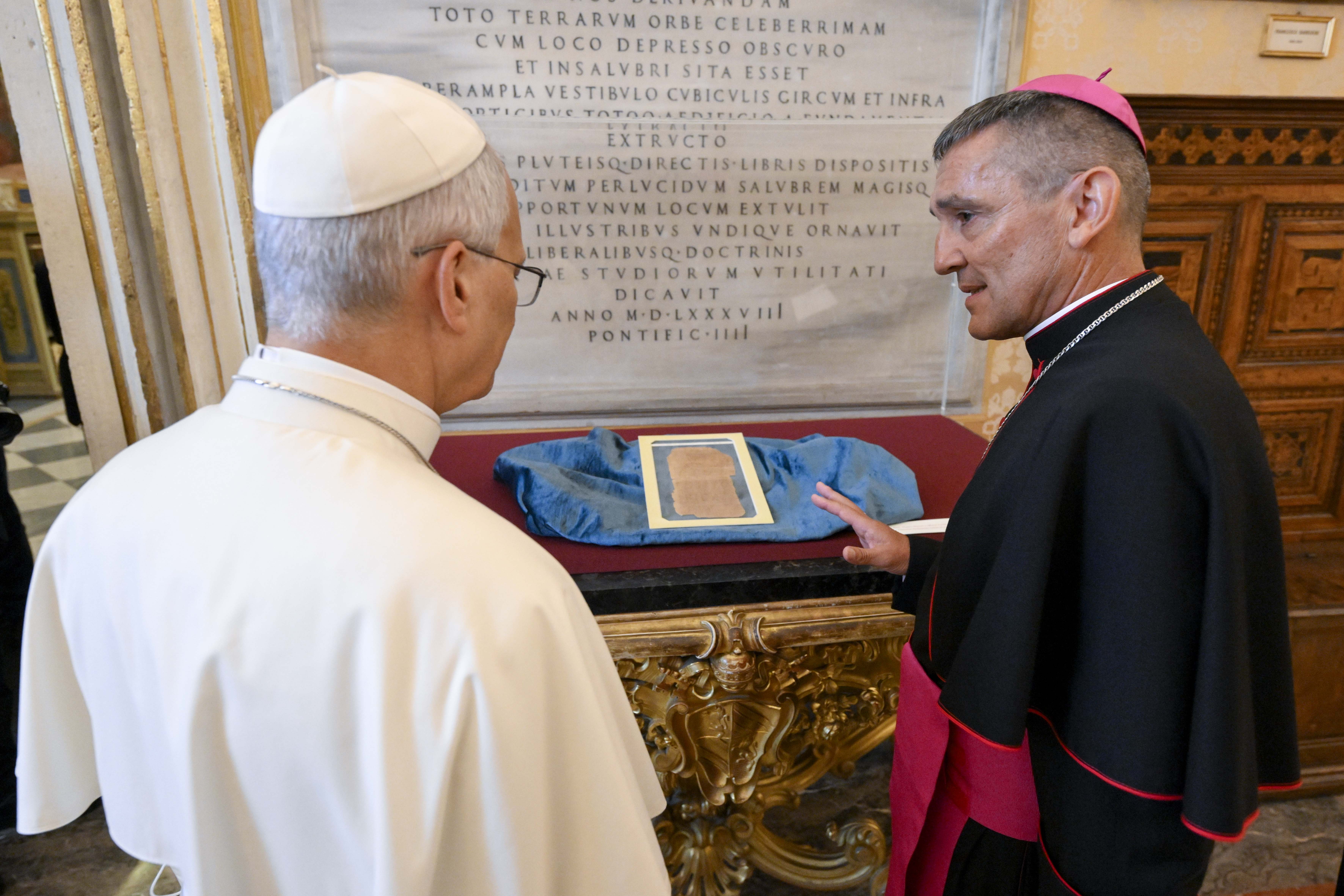 Archbishop Giovanni Cesare Pagazzi, the Holy See’s archivist and librarian, shows Pope Leo XIV one of the artifacts of the Pontifical Apostolic Library during the inauguration of the exhibit “AQVA” on Sept. 14, 2026. | Credit: Vatican Media