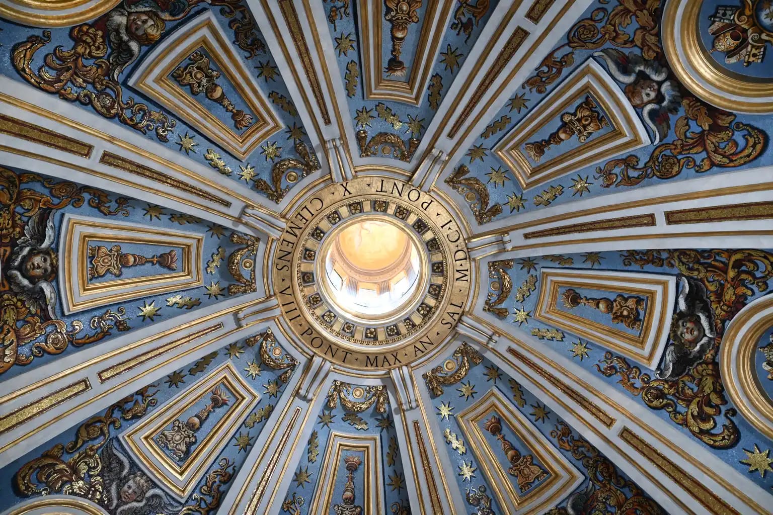 The circular hole contains the name of Pope Clement VIII, who commissioned the Clementine Chapel on the upper floor of St. Peter’s Basilica. The restoration of the dome’s mosaics was completed in September 2026. | Credit: Fabbrica di San Pietro