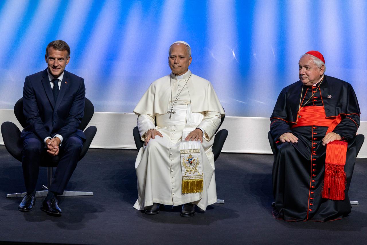 El Papa León XIV, sentado junto al presidente francés Emmanuel Macron y el Cardenal Jean-Marc Aveline, Arzobispo de Marsella, durante el encuentro “Hacia las raíces de Europa por la paz y la unidad”, en el Centro de Conferencias Robert Schuman de Metz (Francia), el 28 de septiembre de 2026. Crédito: Daniel Ibáñez / EWTN News