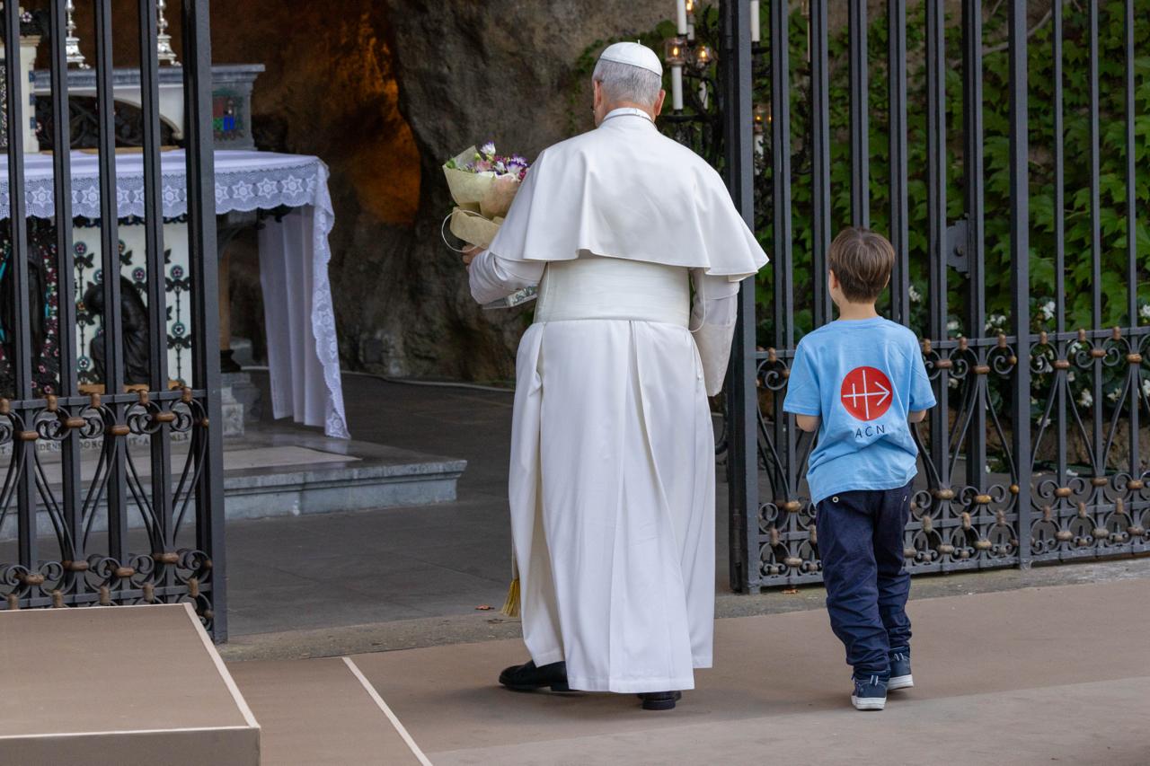 Pope Leo XIV brings flowers to Mary at a replica of the grotto of the Sanctuary of Our Lady of Lourdes during a rosary prayed with children in the Vatican Gardens on Oct. 1, 2026. | Credit: Daniel Ibáñez/EWTN News/Vatican Pool