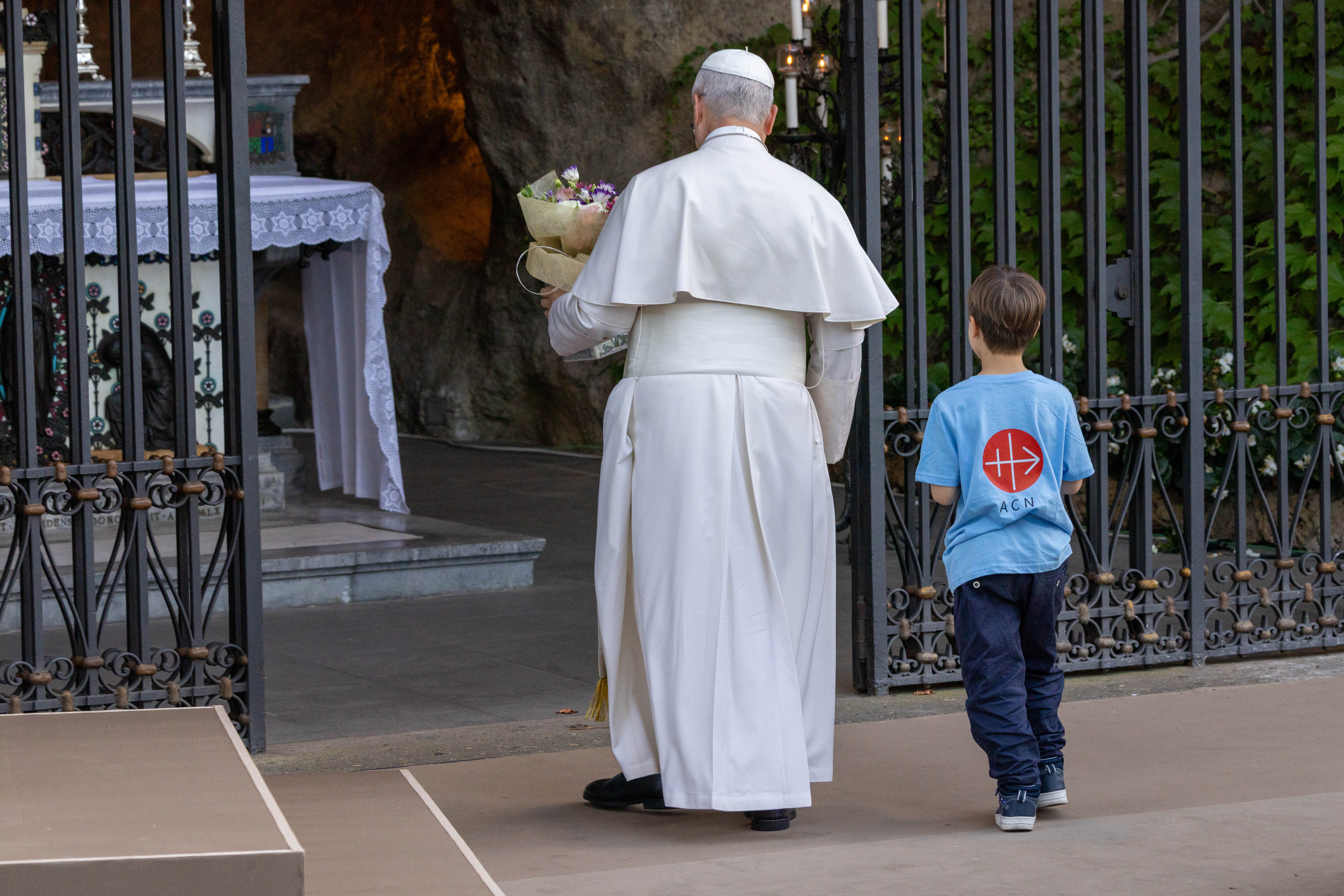 El Papa León XIV lleva flores a la Virgen María en una réplica de la gruta del Santuario de Nuestra Señora de Lourdes durante el rezo del rosario con niños en los Jardines Vaticanos el 1 de octubre de 2026. Crédito: Daniel Ibáñez/EWTN News/Vatican Pool