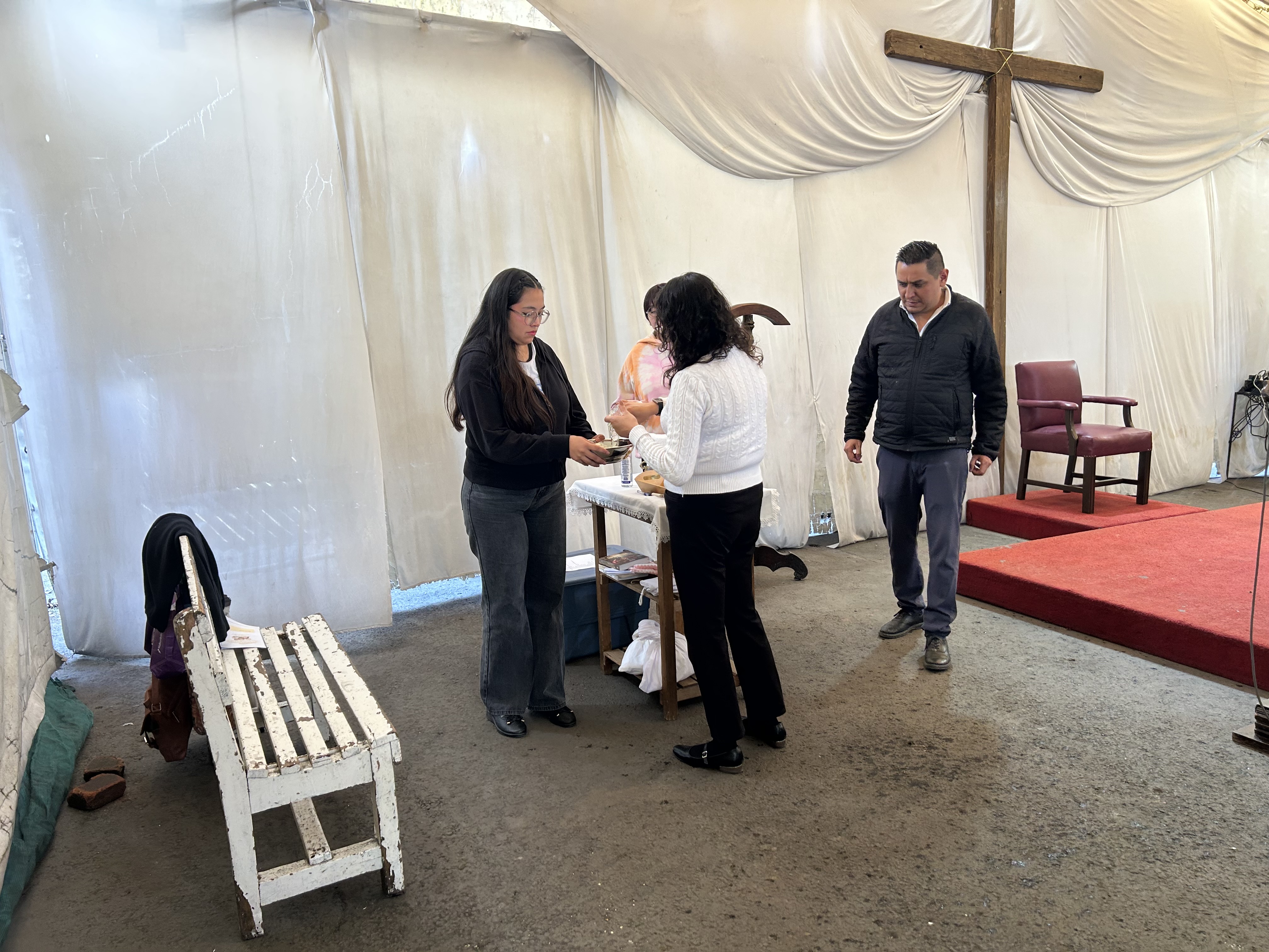 Servidores de la parroquia recogiendo objetos litúrgicos en la carpa instalada a un costado en el santuario parroquial de Nuestra Señora de los Ángeles en una Misa del 18 de octubre de 2026. Crédito: EWTN News en Español.