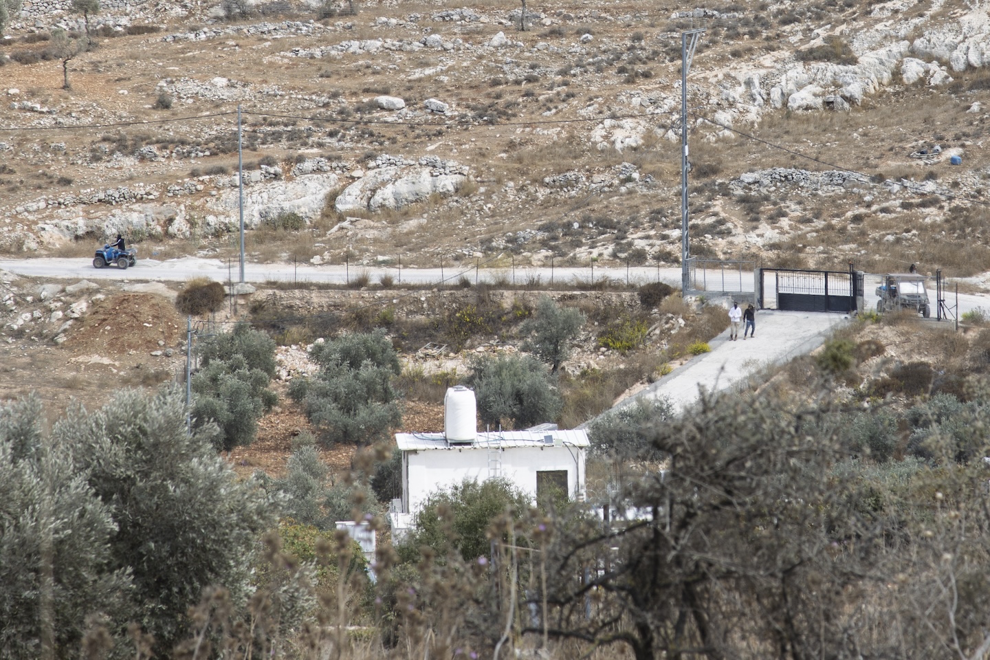 Settlers prepare to enter a resident's home in Taybeh. Repeated attacks and vandalism have prevented the owner from moving in, even seven years after its construction. | Credit: Sanad Sahelia