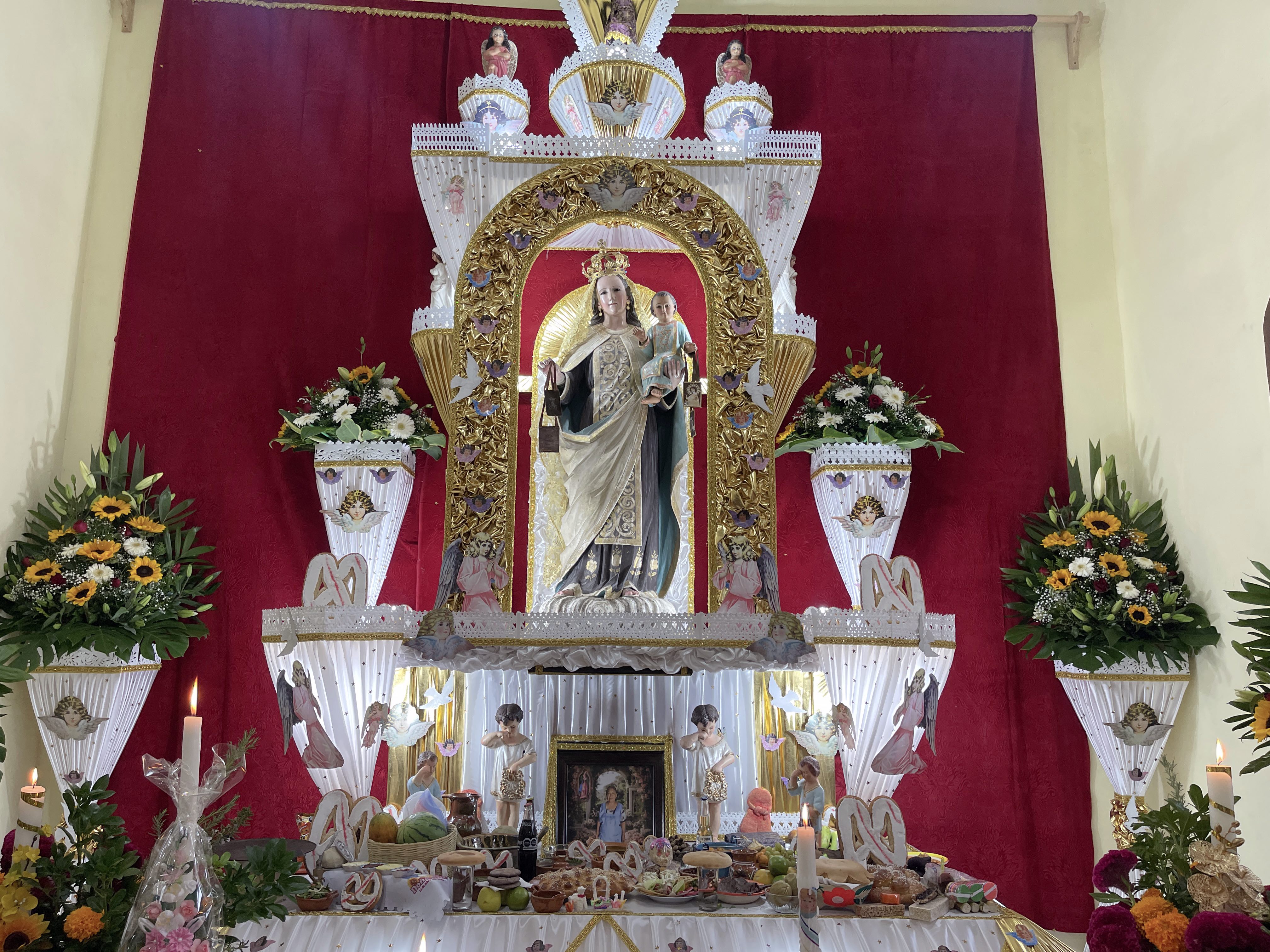 Altar monumental de Día de Muertos en Huaquechula, Puebla (México), con flores, velas, alimentos, fotografía del difunto e imágenes religiosas, el 1 de noviembre de 2025. | Crédito: David Ramos/EWTN News.