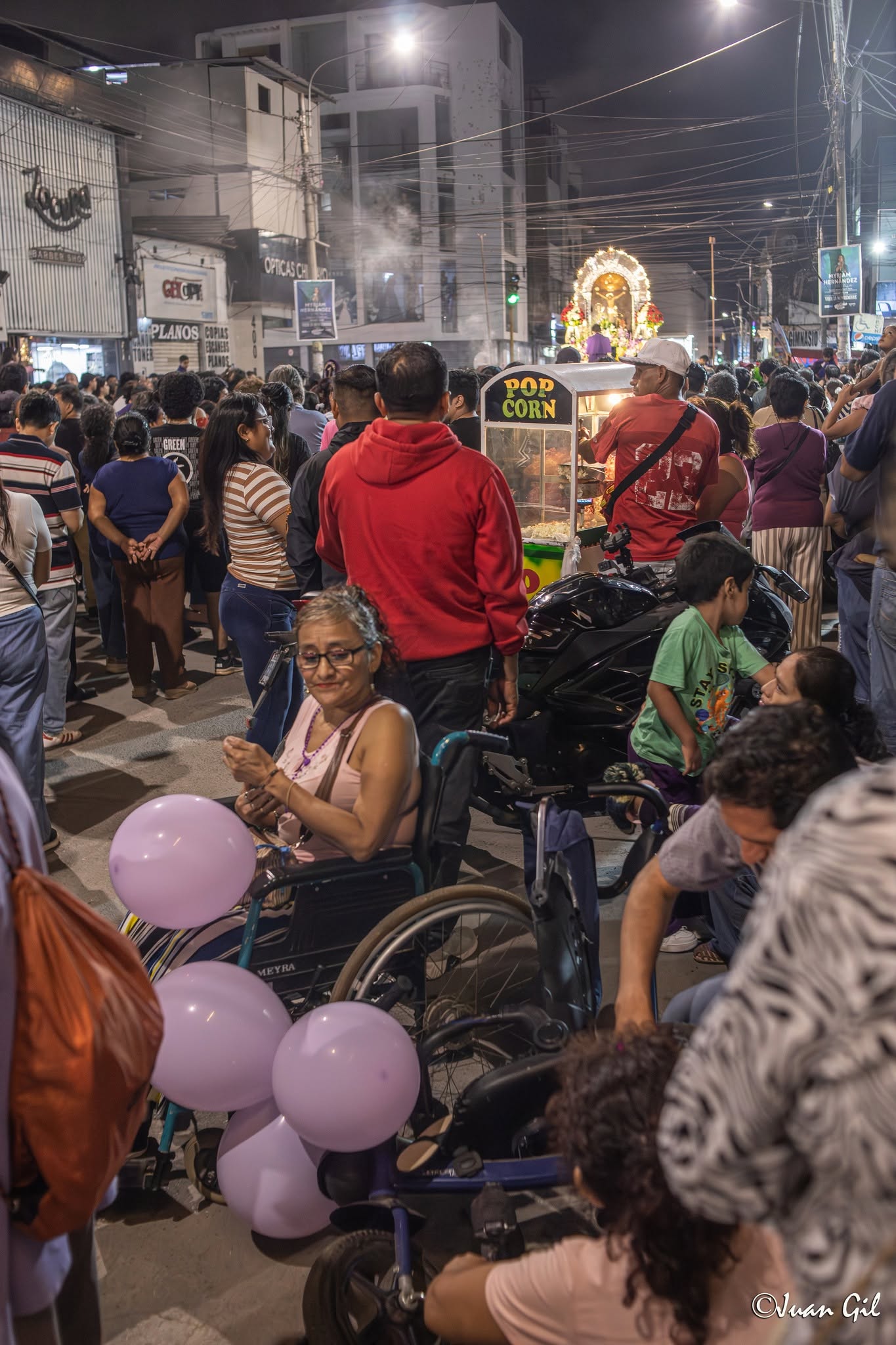 Inclusión en la festividad. Una fiel en silla de rodeada de globos morados, mostrando que la devoción no conoce barreras físicas. Foto: Juan Gil