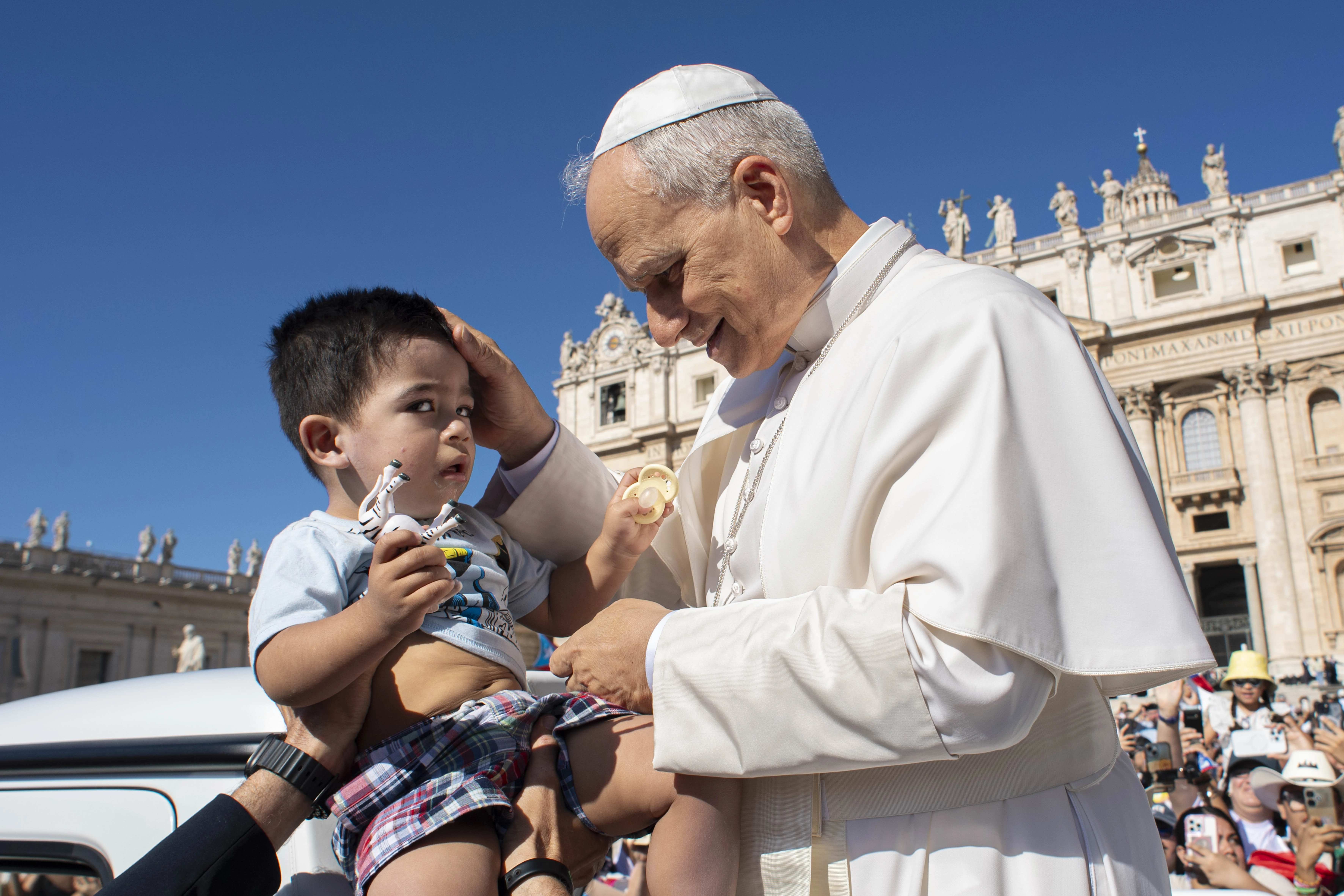 Paus Leo XIV zegent een peuter tijdens zijn algemene audiëntie op 30 juli 2025, op het Sint-Pietersplein in Vaticaanstad. Krediet: Vatican Media
