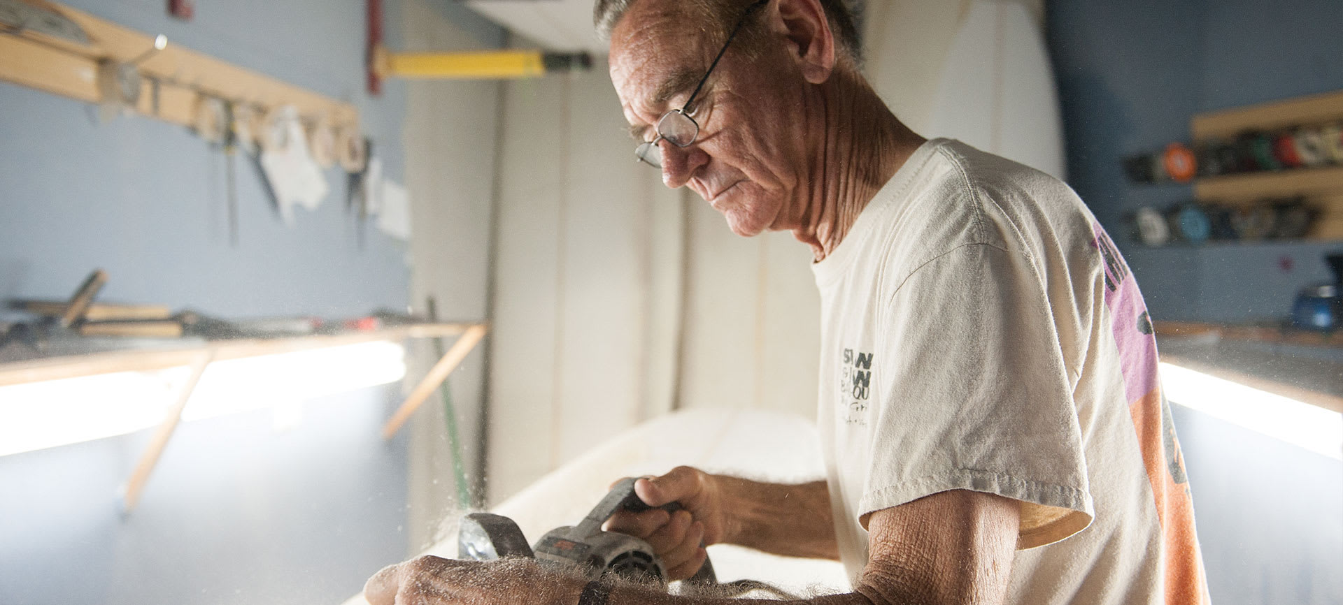 man shaping a surfboard