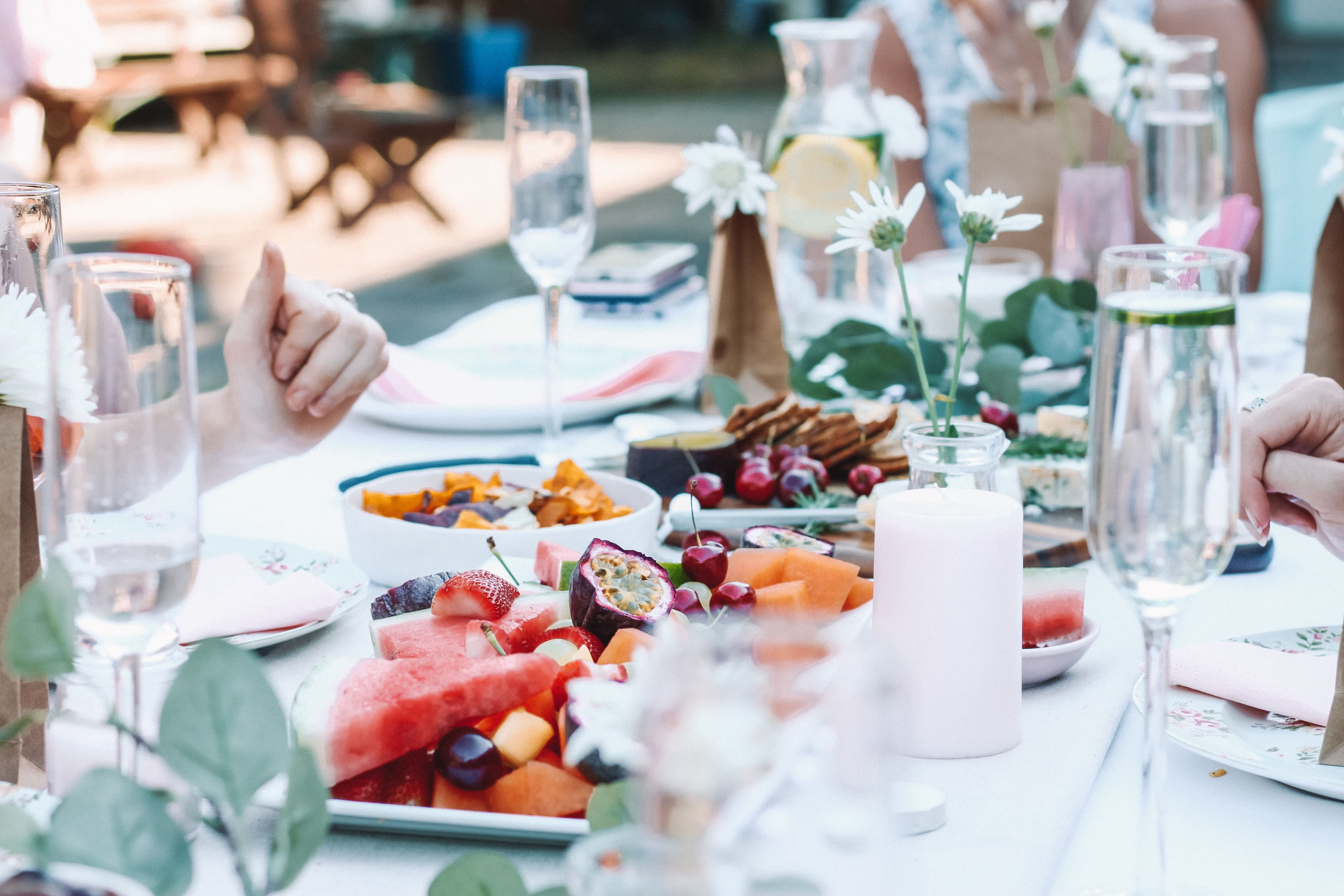 Elegant outdoor dining table set with fresh fruits and champagne, showcasing a Provence-style meal.