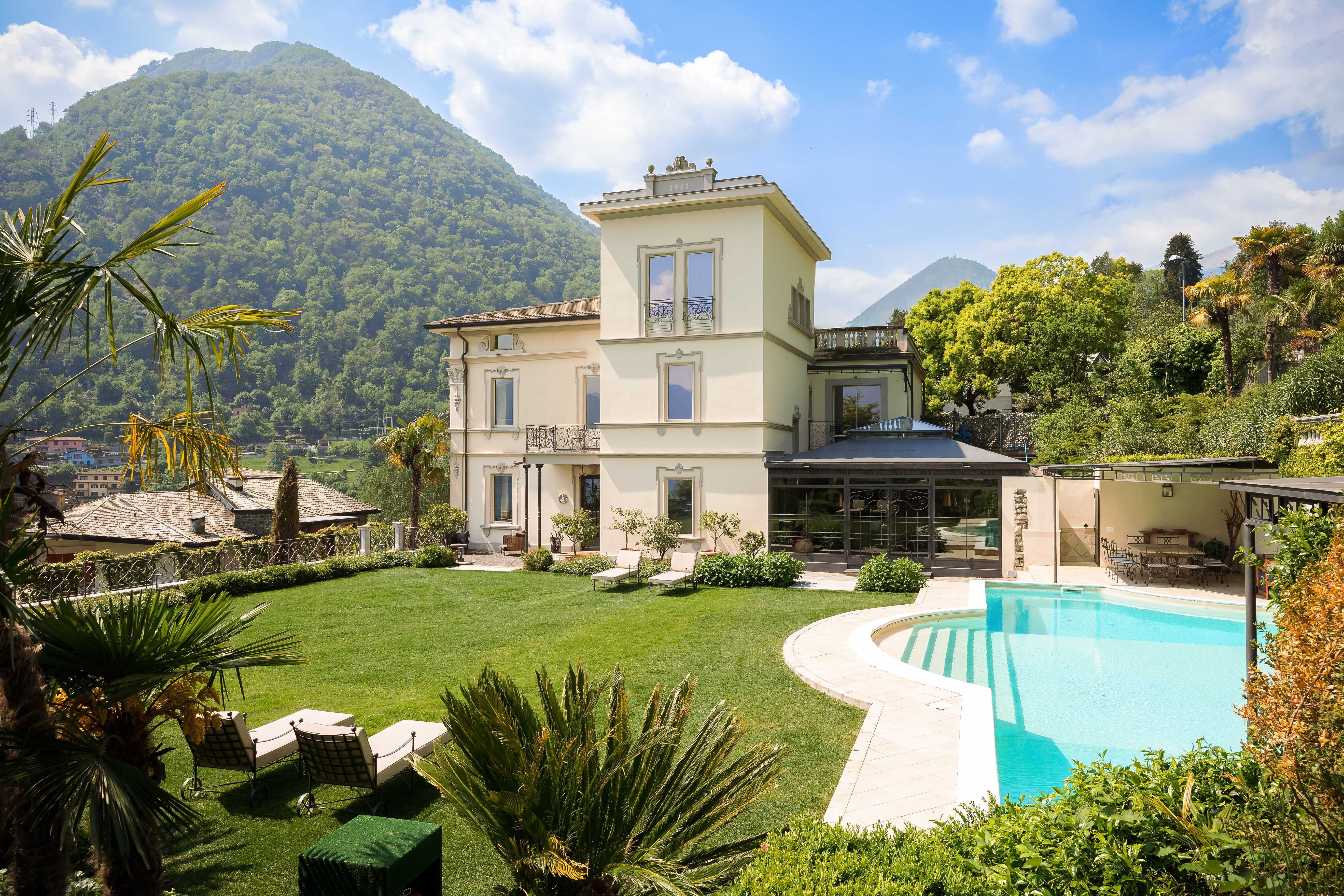 Exclusive Resorts' luxury villa in Lake Como, Italy, with a private pool and lush gardens surrounded by mountains.