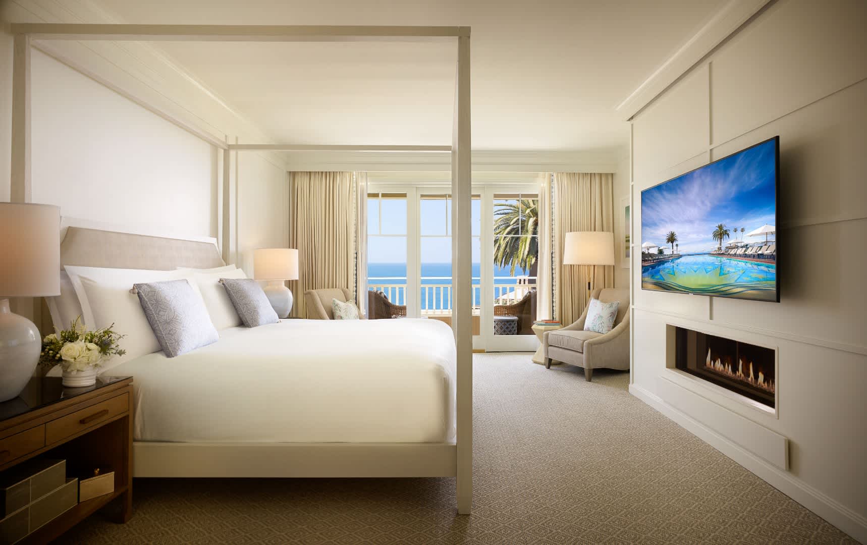 Exclusive Resorts' master bedroom suite at Montage Laguna Beach with ocean view, elegant decor, and luxurious bedding.