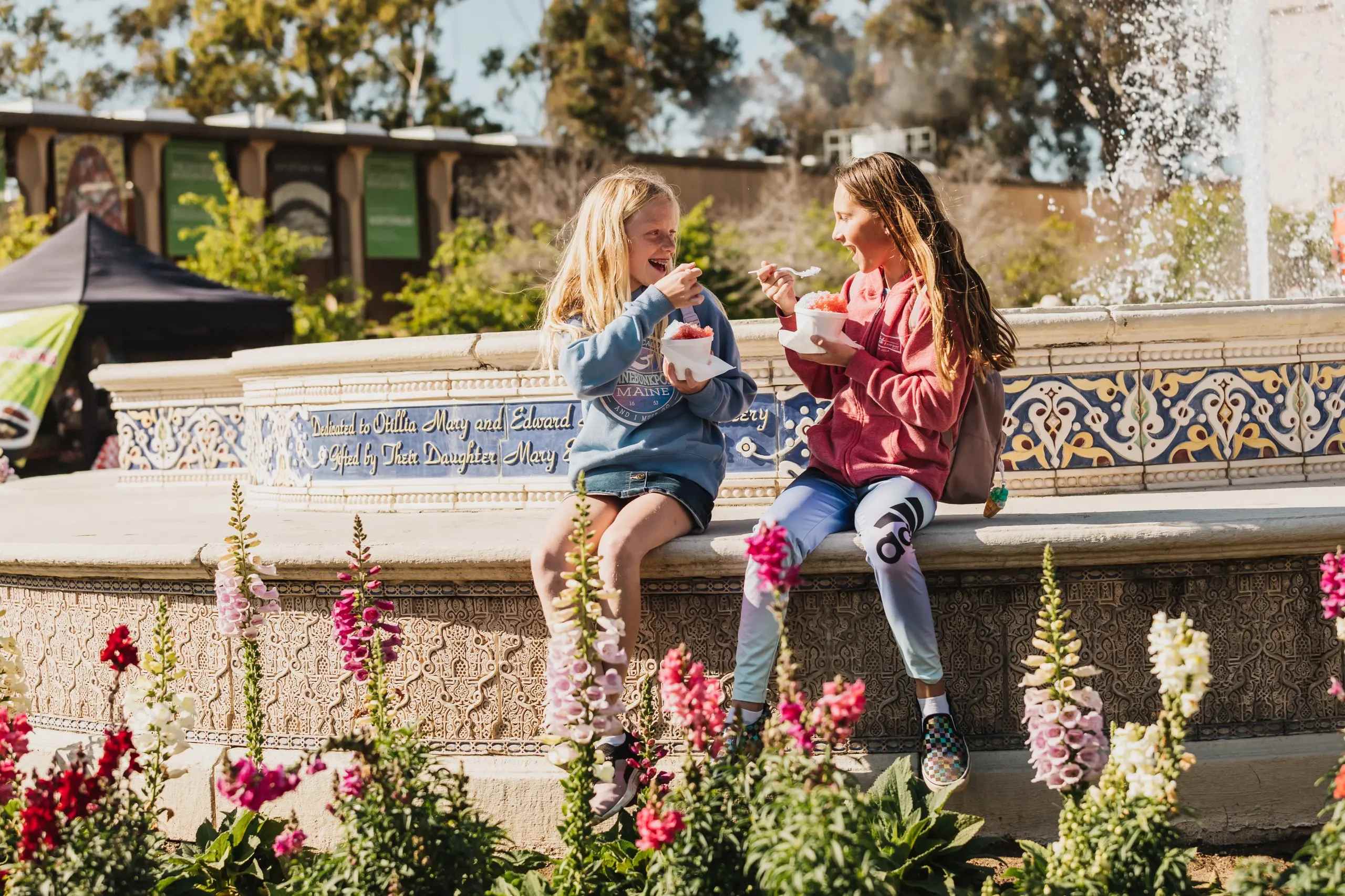 Children enjoying ice cream by a fountain in Balboa Park in La Jolla.