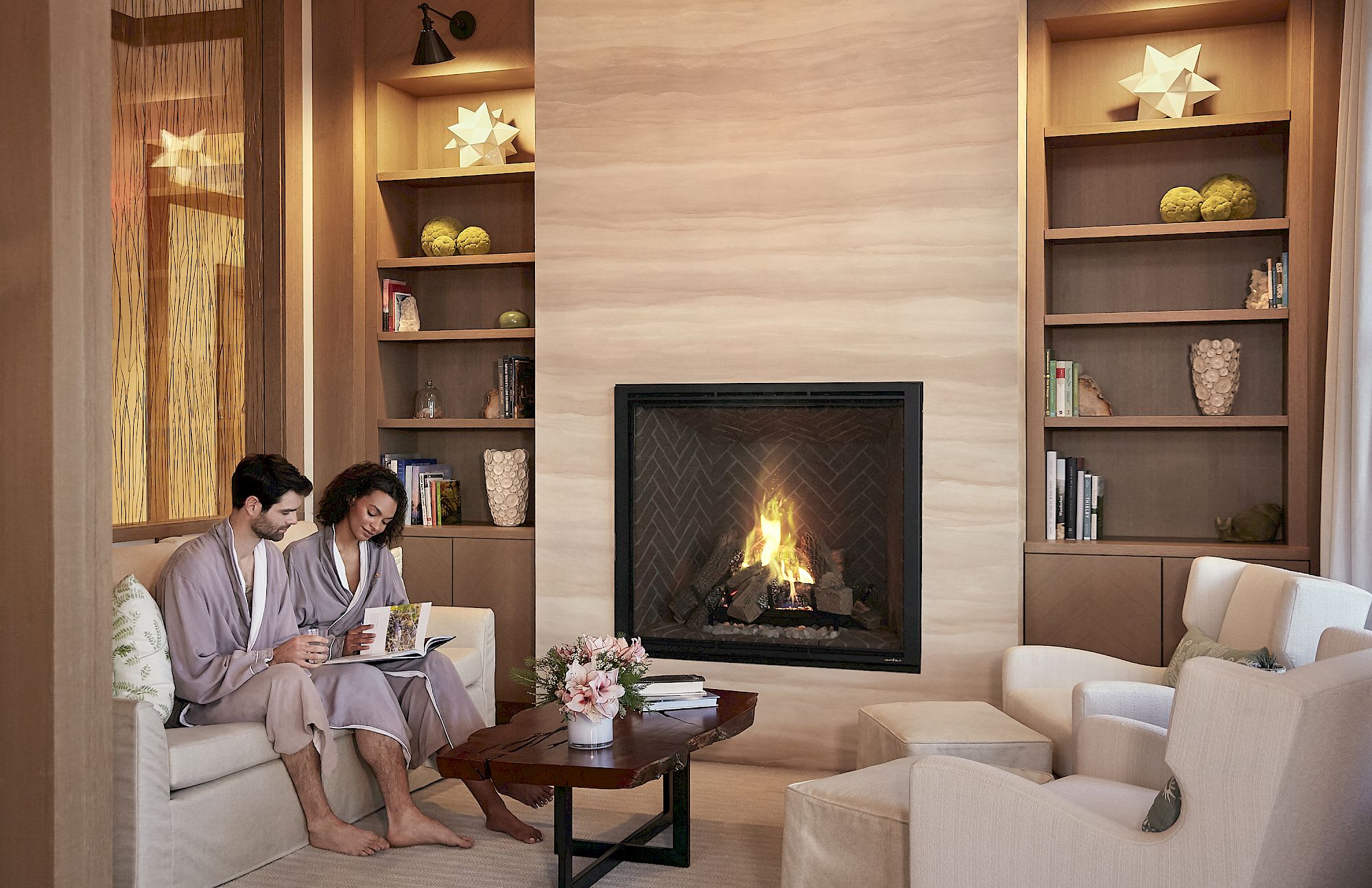 Couple relaxing in robes by a fireplace at the Spa at Carneros.