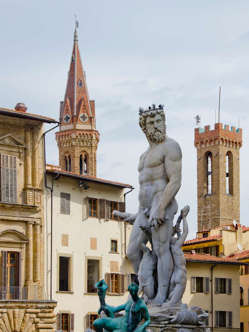 Statue of Neptune with historic buildings and towers in Piazza della Signoria, Florence, Italy