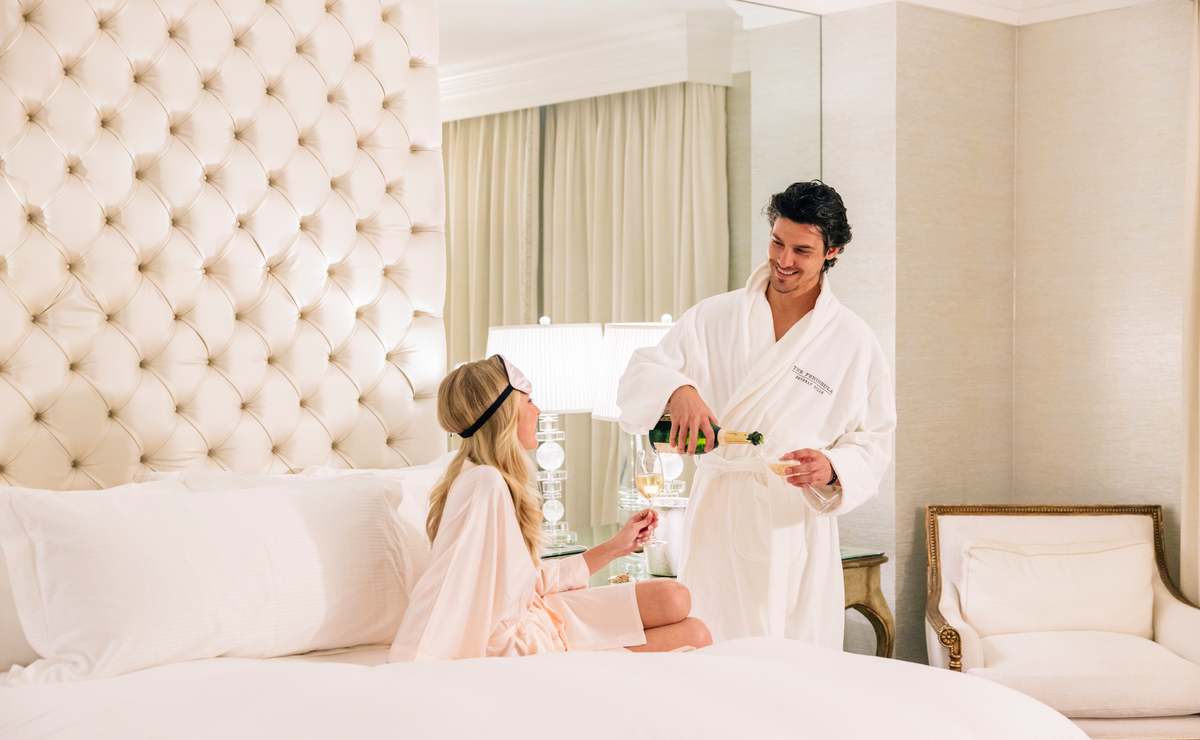 Couple enjoying champagne in a luxurious room at The Peninsula Beverly Hills hotel.