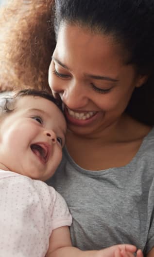 Mamá con un bebé en brazos y sonriéndose