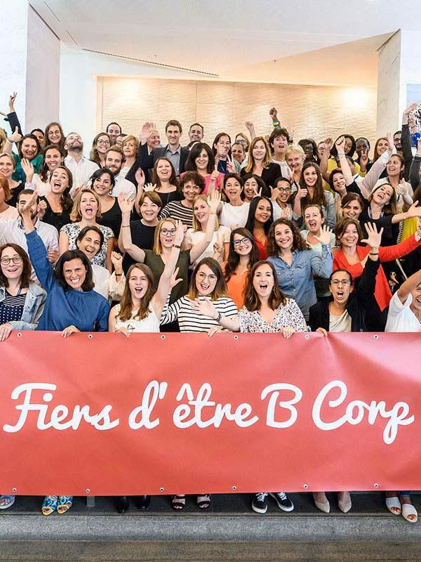 Groupe de collaborateurs Expanscience tenant une banderole Fiers d'être B Corp