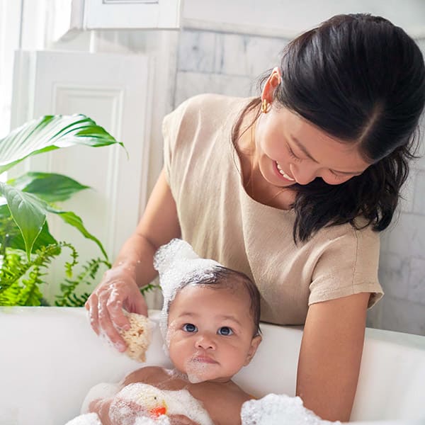 Uma mãe dá banho em seu bebê