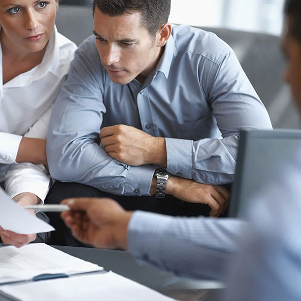 Three employees reviewing a contract