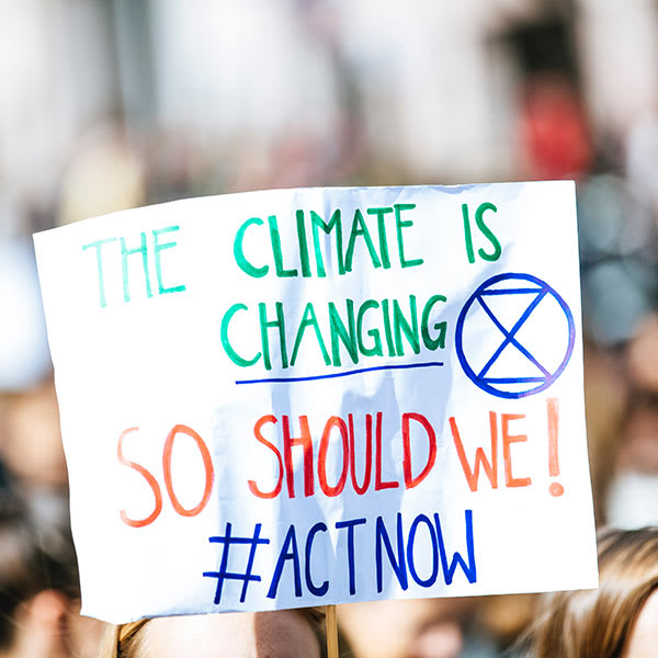 Manifestazione per il clima con un cartello Il clima sta cambiando, quindi dobbiamo agire ora!