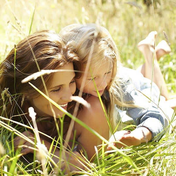 A mother and her daughter lying in the grass