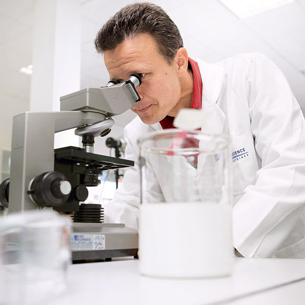 Researcher looking through a microscope