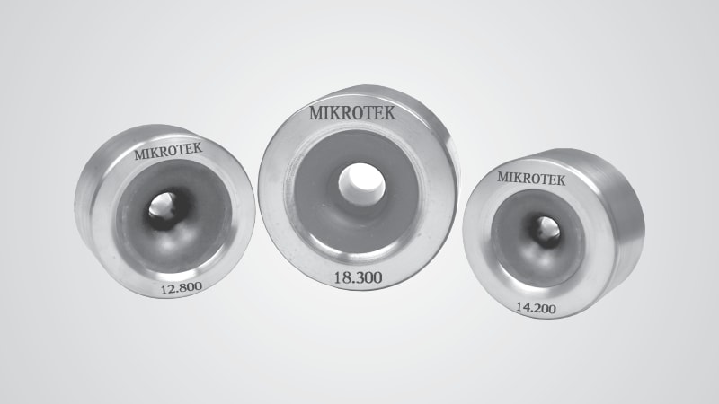 Three metallic MIKROTEK industrial dies, showing sizes 12.800, 18.300, and 14.200 engraved on their surfaces.