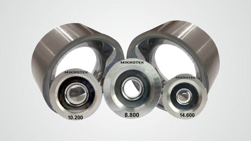 Mikrotek precision industrial components: two large metal rollers and three bearings, labeled 10.200, 8.800, and 14.600.