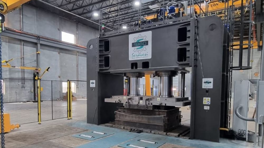 Heavy industrial Seravesi hydraulic press with 1960 branding inside a manufacturing facility, showing its robust structure and tooling.
