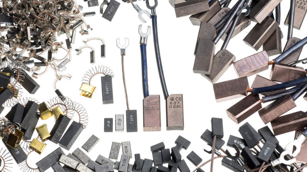Assortment of new carbon brushes with springs, wires, and various connectors, suitable for electric motors and power tools.