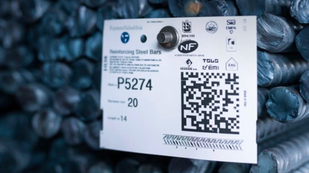 Etichetta di identificazione del prodotto FerroValdabbia attaccata a un fascio di barre d'acciaio per cemento armato, che mostra il codice P5274, diametro 20mm, lunghezza 14m, loghi di certificazione e un QR code.