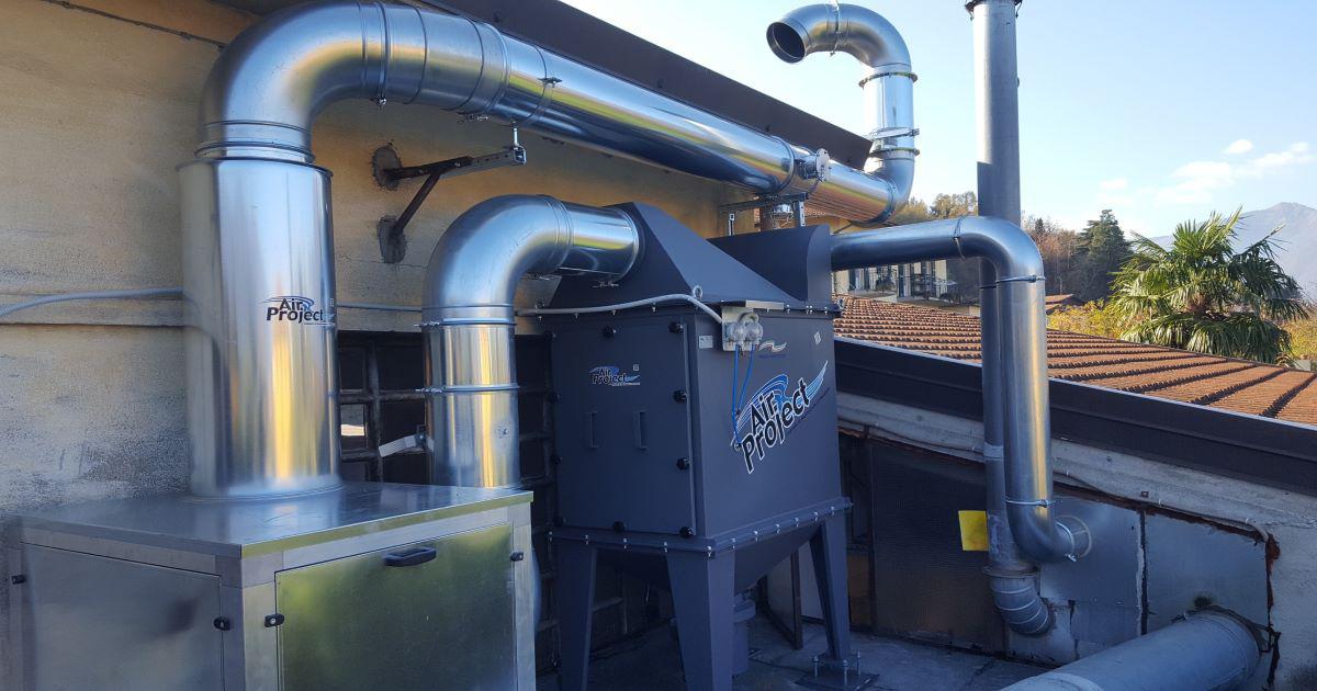 Industrial air purification and filtration system with galvanized ducts and 'Air Project' branded units installed outdoors on a building rooftop.
