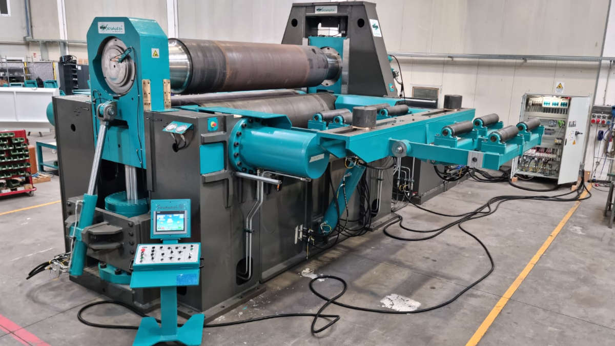 Bernini four-roll plate rolling machine in teal and dark grey in a factory setting, featuring large main rollers, an auxiliary support frame, and a freestanding control panel.