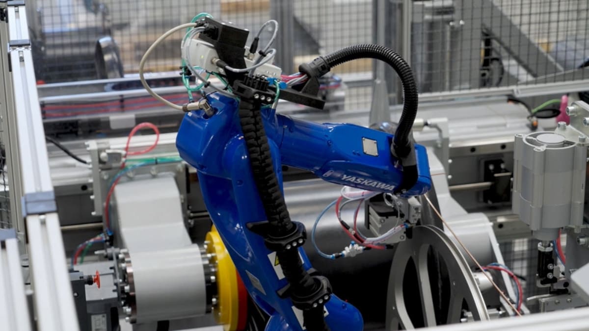 Robot-assisted layer winding station for magnet wire with automated handling system