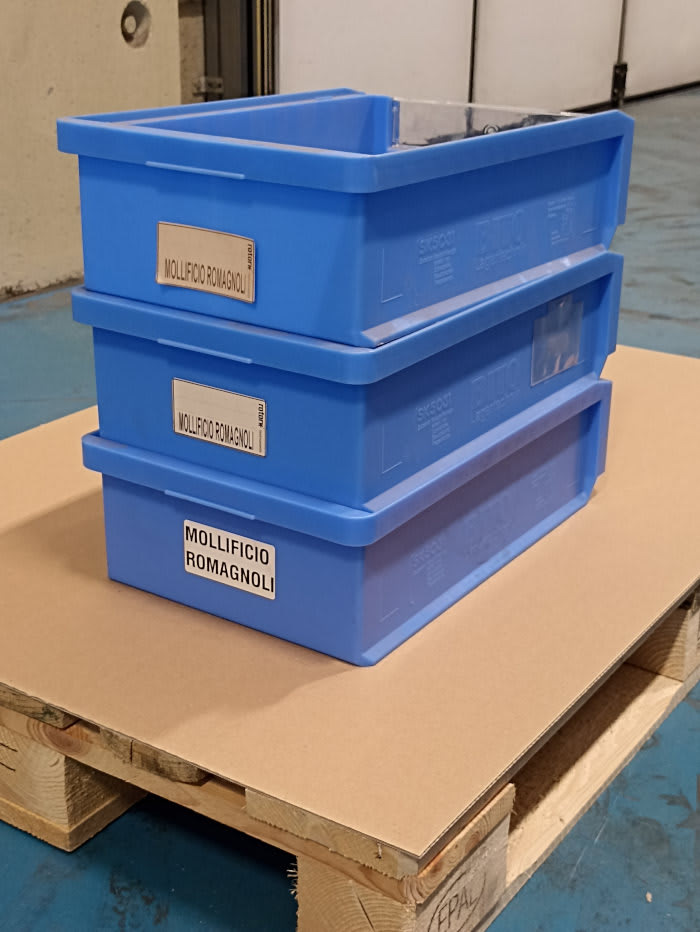 Tre cassette in plastica blu impilate con etichette Mollificio Romagnoli su un pallet EPAL in un ambiente industriale.
