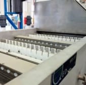 Industrial electrochemical processing unit with multiple parallel rows of white electrodes inside a tank, typically used for electroplating or water treatment.