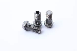 Four metallic banjo bolts for hydraulic systems, showing threaded shafts and drilled fluid passages.