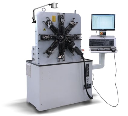 Automated CNC spring and wire bending machine with a multi-station rotary head, connected to a dedicated computer control system.