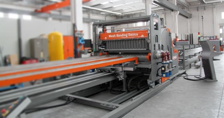 Industrielle Drahtgitter-Biegeanlage mit orangefarbenem Förderband in einer modernen Fertigungshalle.