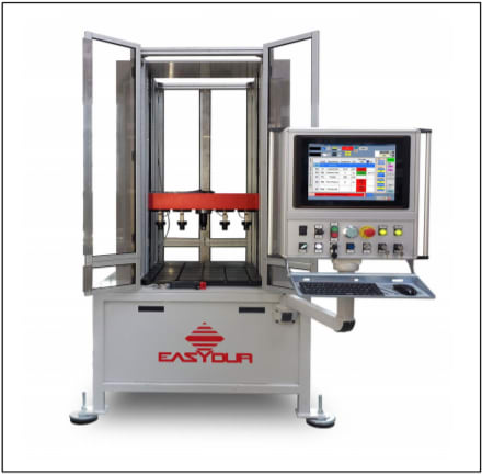 Macchina di prova automatica industriale EASYDUR con pannello di controllo touchscreen, tastiera, mouse e vano di lavoro aperto che mostra attuatori rossi e piattaforma interna.
