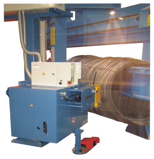 Macchinario industriale blu per la lavorazione e piegatura del filo metallico, con pannello di controllo bianco e bobina di tondino sullo sfondo.